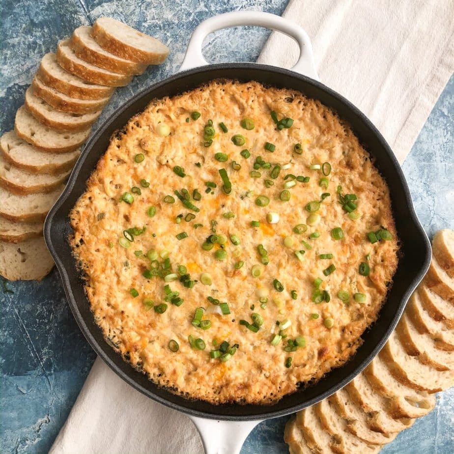 skillet filled with crab dip and served with slices of bread