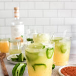 spicy margaritas over ice with garnishes spread around the table