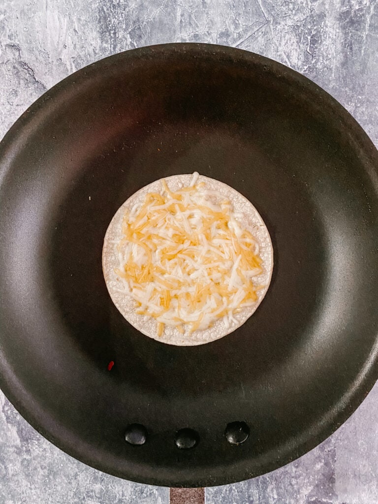 corn tortilla with melted cheese in a large skillet