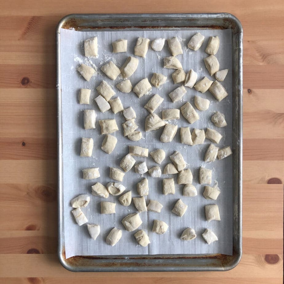 dough cut into small pieces on a sheet tray waiting to be boiled