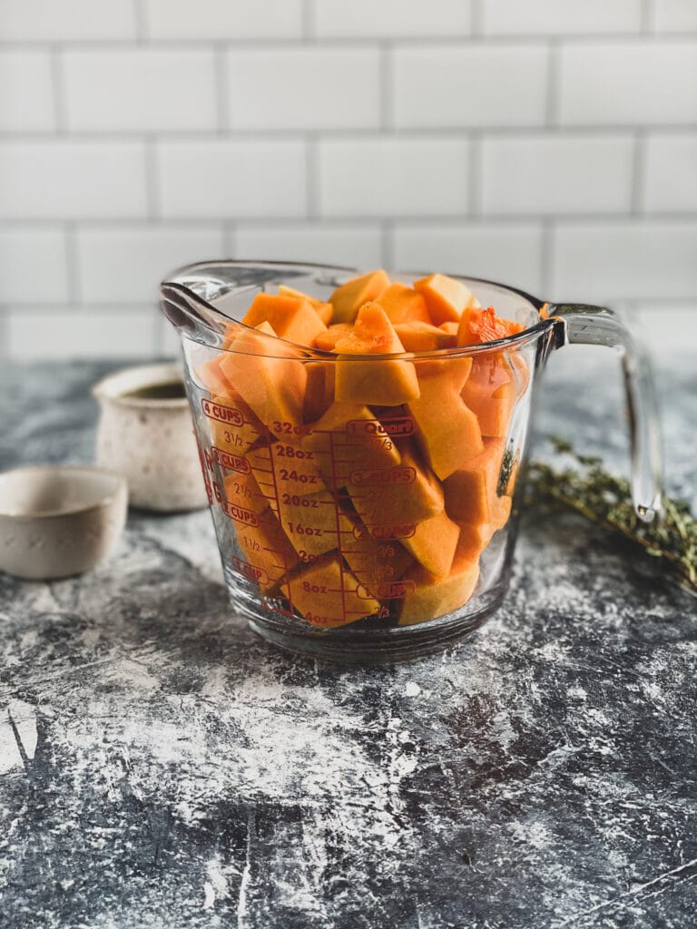 butternut squash cut into cubes in a measuring cup