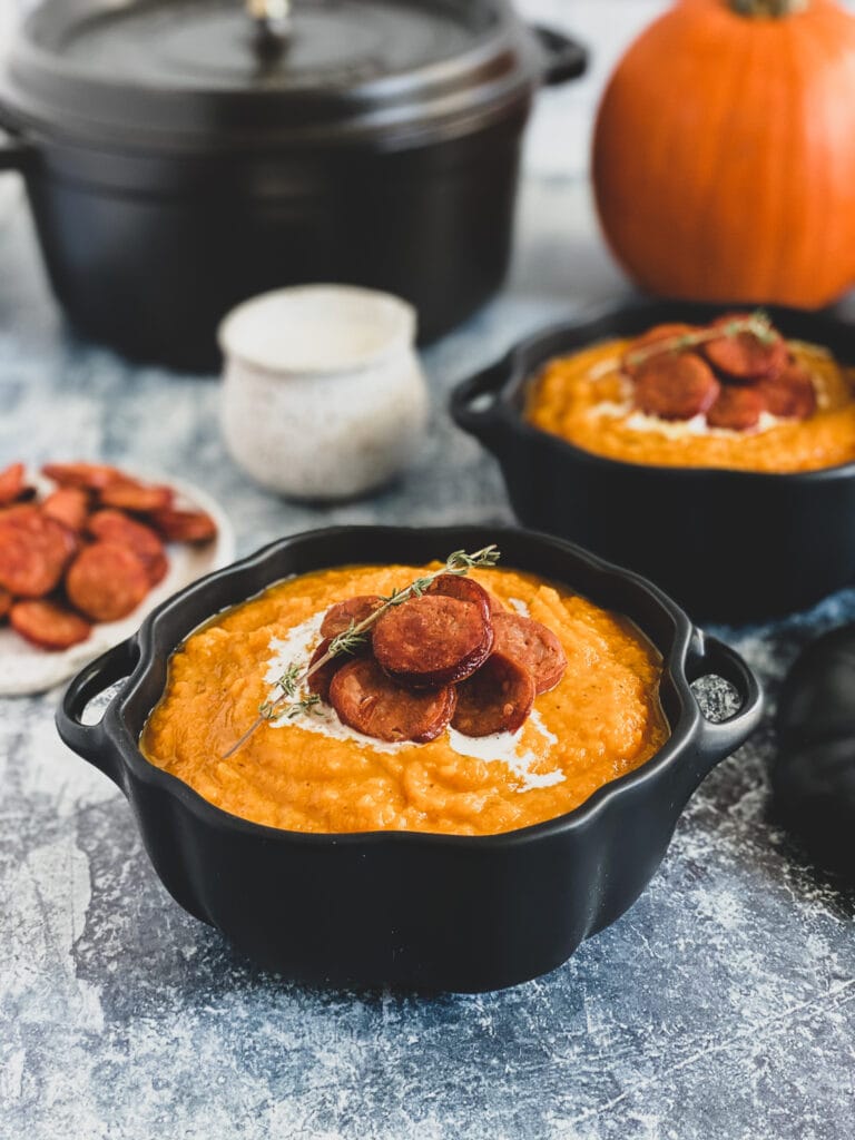 butternut squash soup with linguica and thyme served with cream in a ceramic pumpkin 