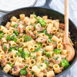 creamy chicken pasta in cast iron skillet with wooden spoon