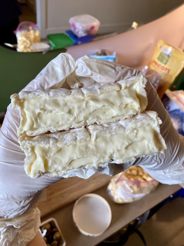 wheels of brie cut in half to show the gooey insides