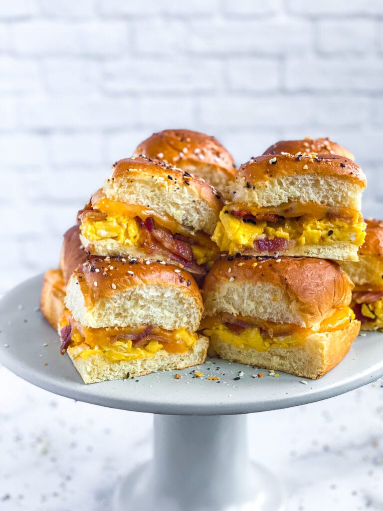 side view of sliced everything bagel breakfast sliders on a cake stand for serving