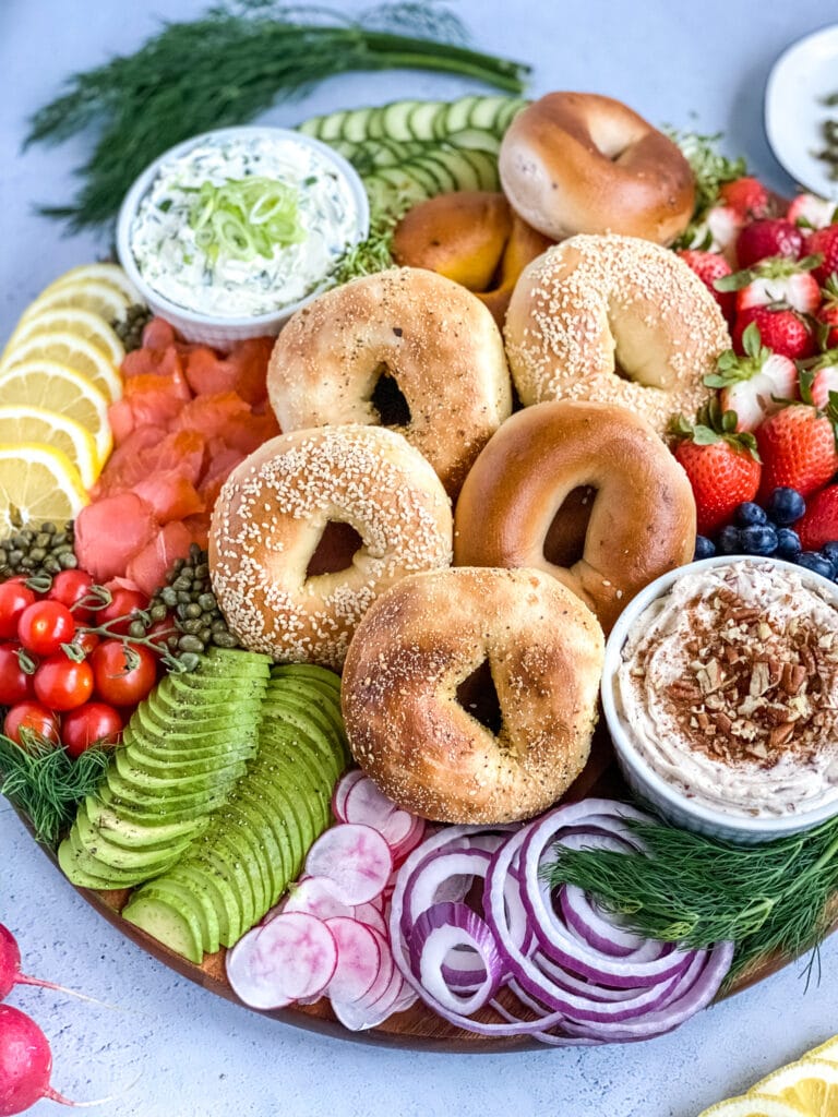 assembled bagel board with bagels, lox, vegetables and cream cheeses.