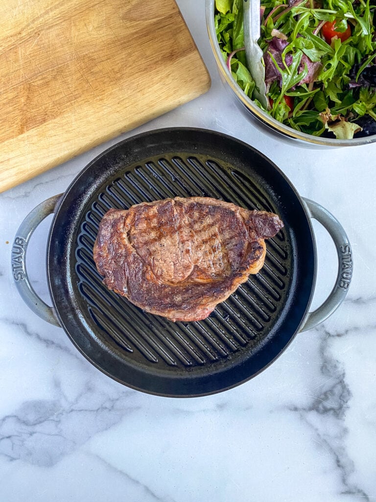 ribeye steak perfectly seared on a grill pan