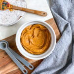 flavored chili butter in a small ramekin with measuring spoons and mini spatula in the frame