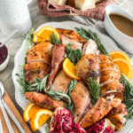 whole roasted turkey on a serving platter on the thanksgiving table