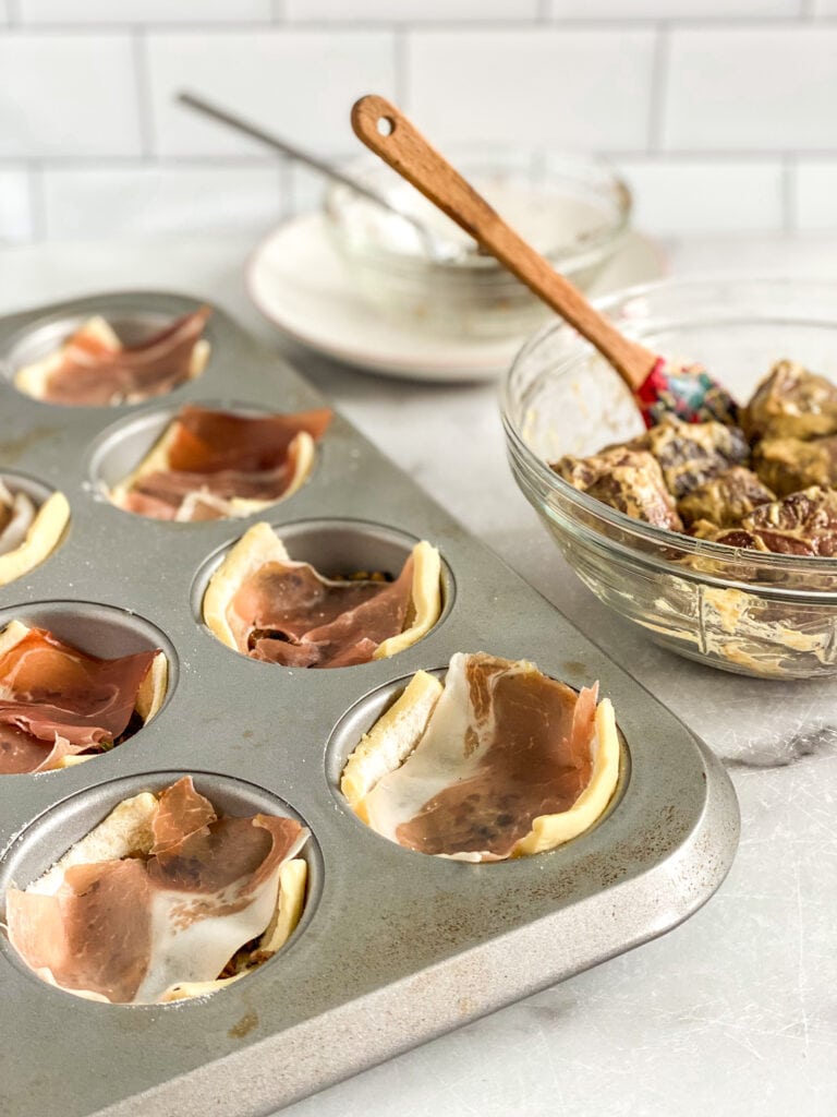 muffin pan filled with puff pastry and mushrooms and prosciutto 