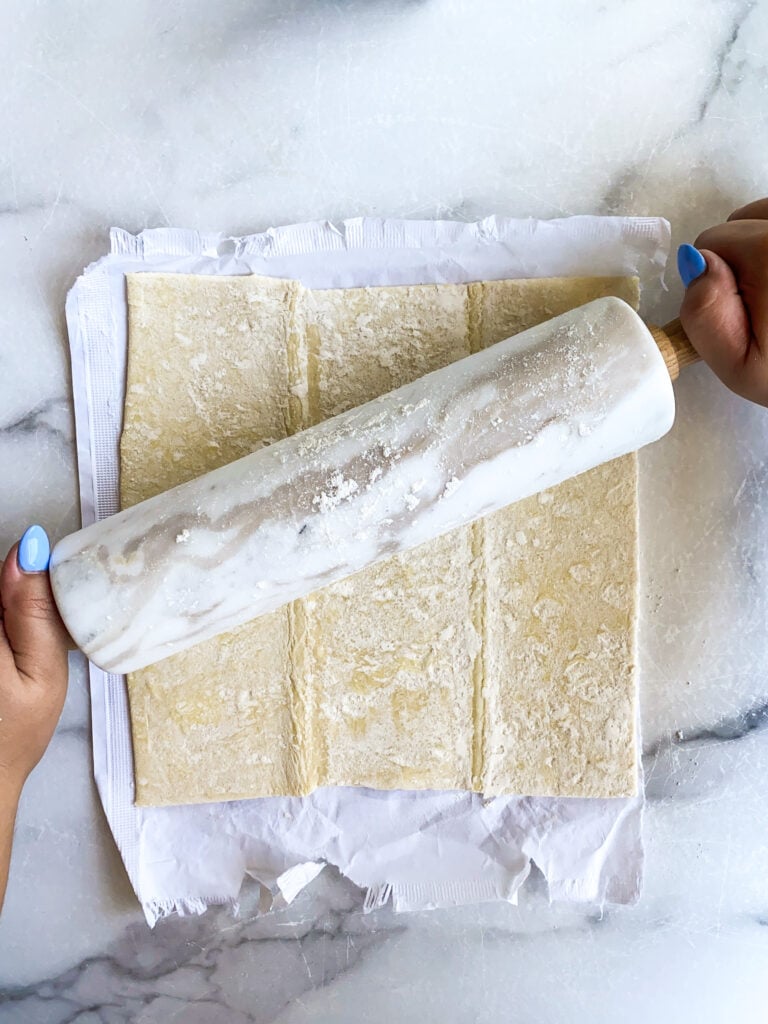 rolling pin rolling out a sheet of puff pastry