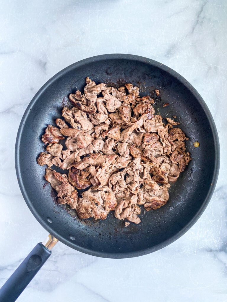 overhead shot of cooked ribeye meat in saute pan